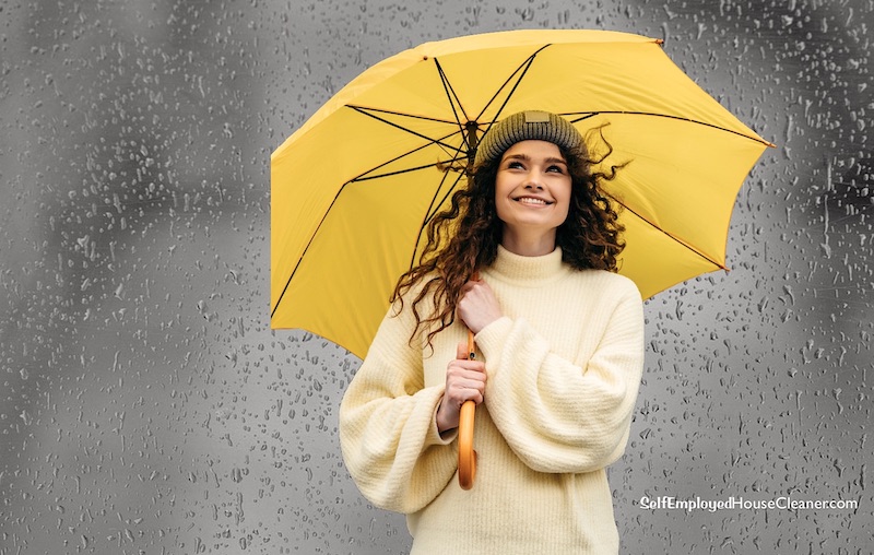 Woman holding a yellow umbrella as insurance for rainy days